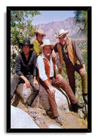 Framed Bonanza wall art print portrays four cowboy-hatted men posed on sunlit boulders, with trees and rugged mountains behind them.