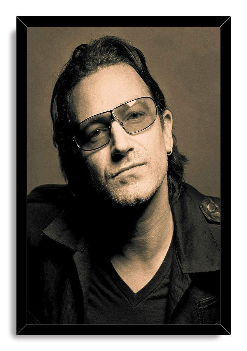 Bono framed wall art print displays a sepia portrait of the singer in glasses and a dark jacket within a slim black frame.