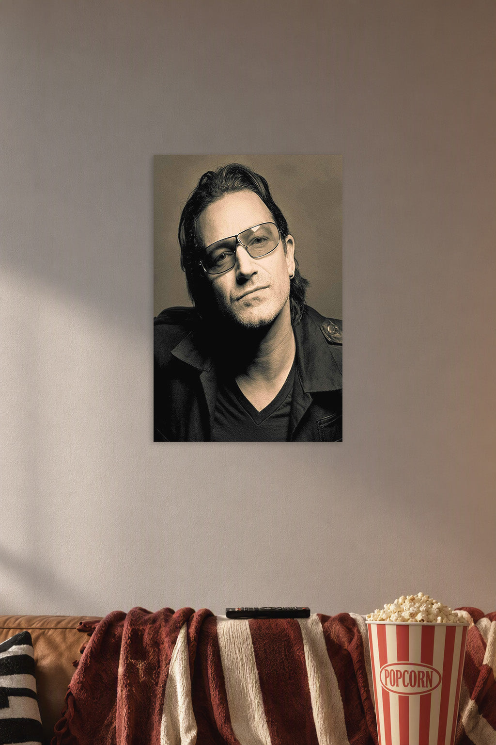 Bono in a cozy movie room above a brown sofa with popcorn.