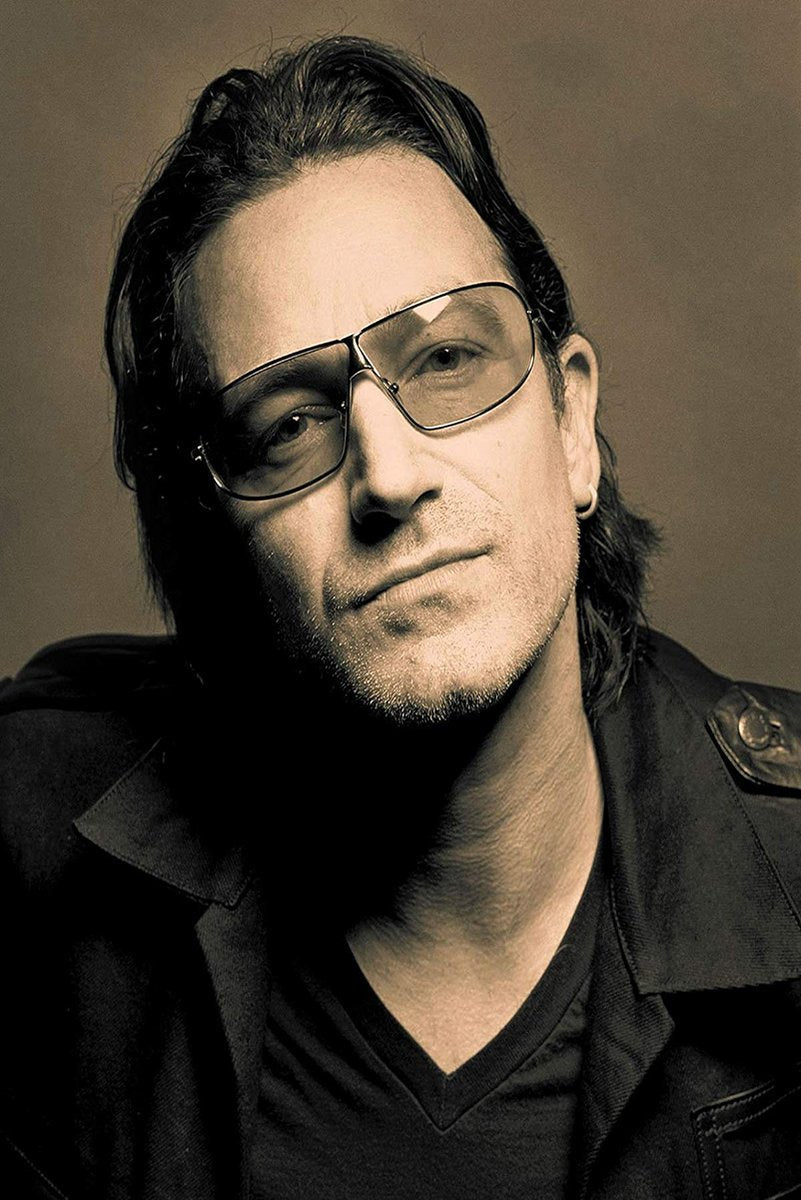 Bono poster features a close sepia portrait of the singer in tinted glasses, a hoop earring, and a dark jacket.