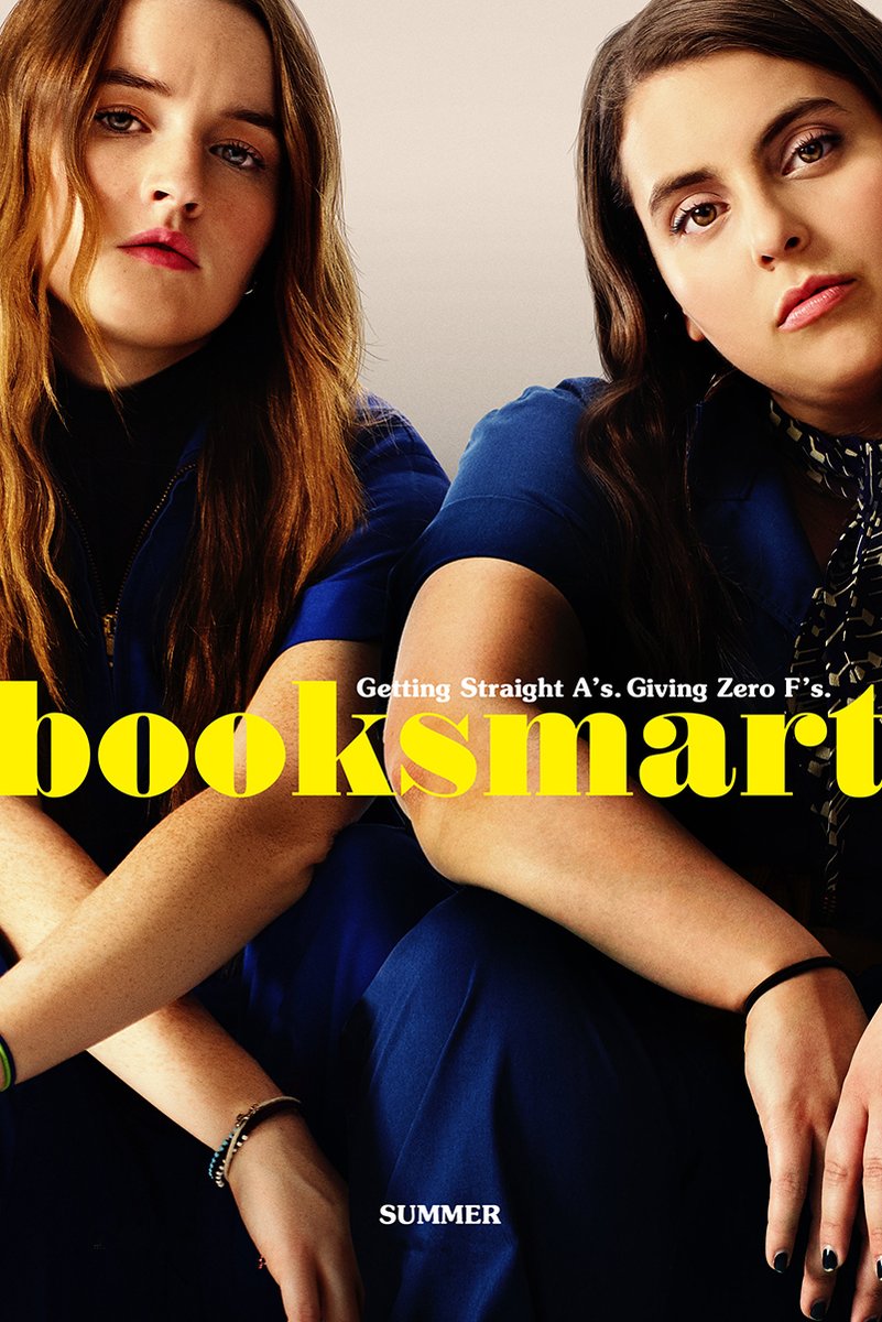 Booksmart poster featuring two young women in blue outfits seated close together, with bold yellow title text.