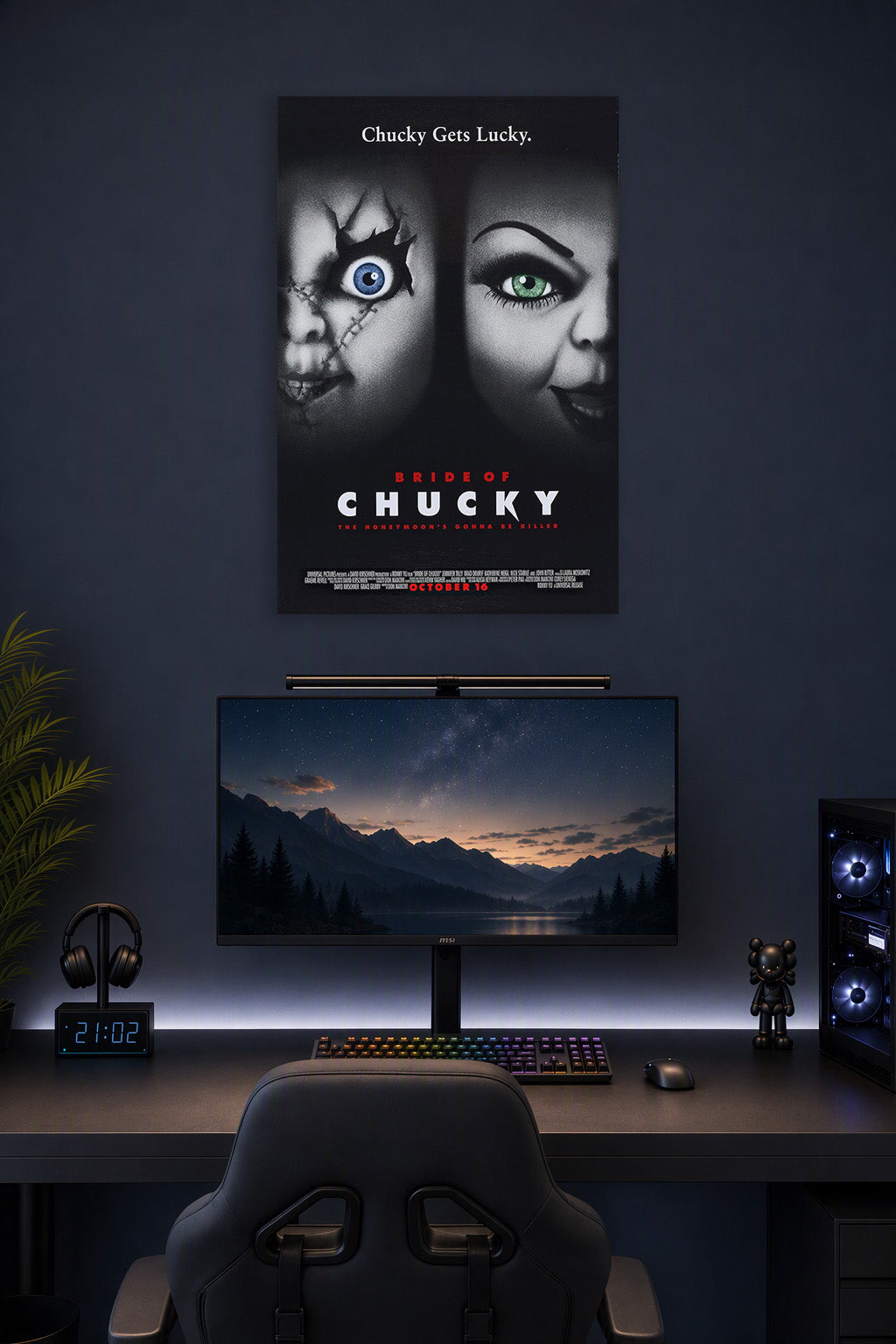 Bride of Chucky in a gaming desk setup above a monitor.