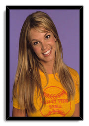 Britney Spears framed wall art print with a black border, portraying her smiling in a yellow T-shirt against purple.