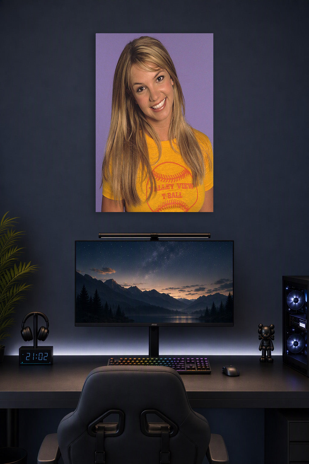 Britney Spears in a gaming desk setup above a monitor.