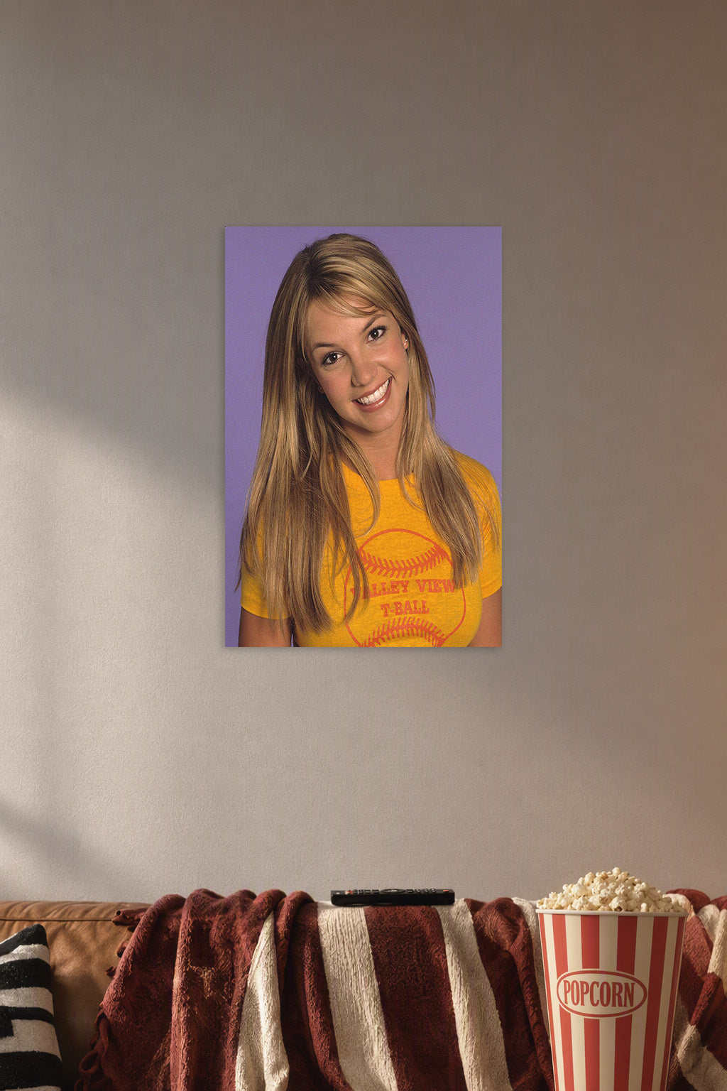 Britney Spears in a cozy movie room above a brown sofa with popcorn.