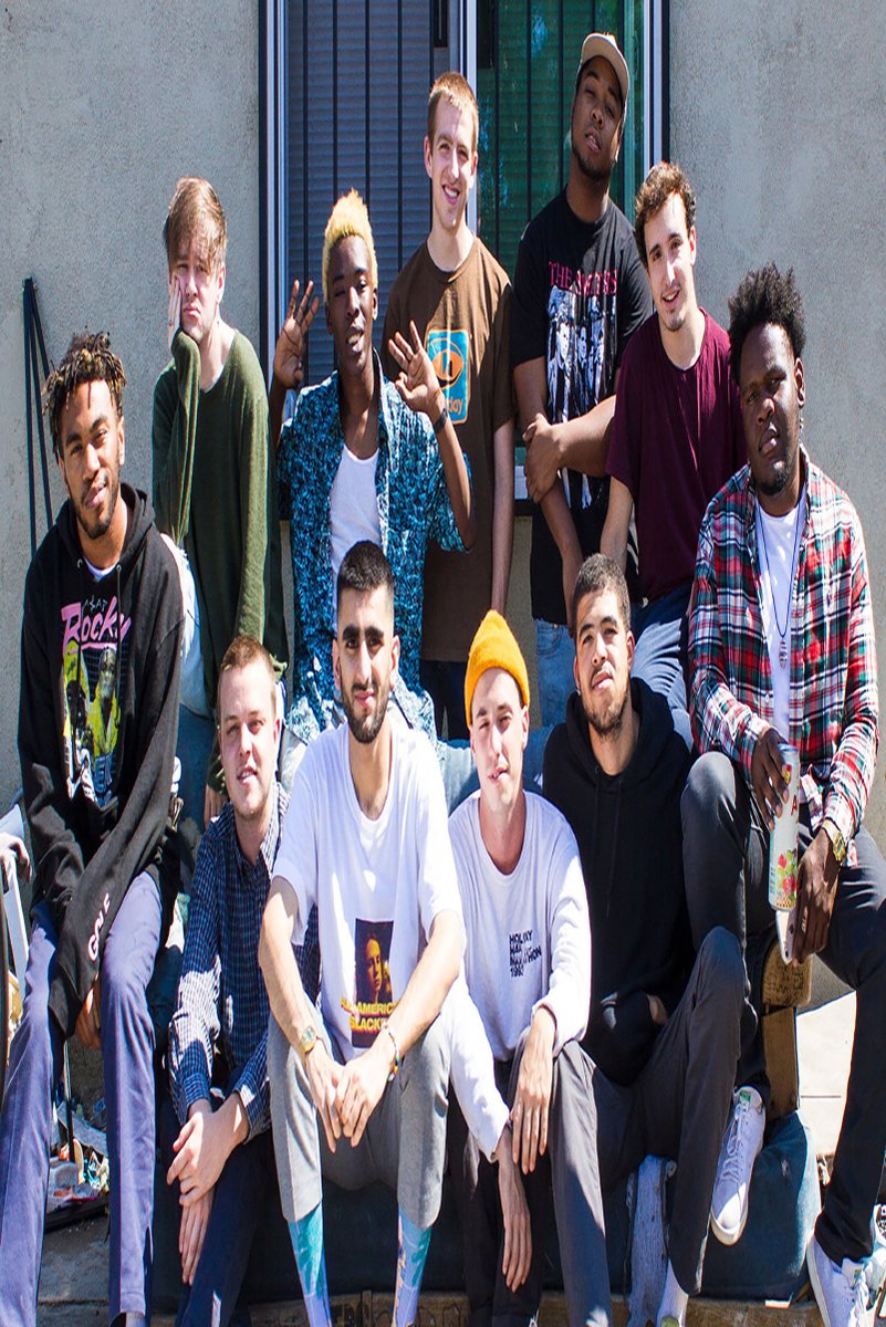 Brockhampton wall art print featuring eleven members gathered outdoors in casual colorful clothing before a gray building.