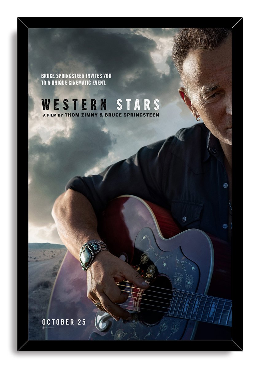 Bruce Springsteen Western Stars wall art print in a black frame portrays him playing a decorated guitar under dramatic clouds.