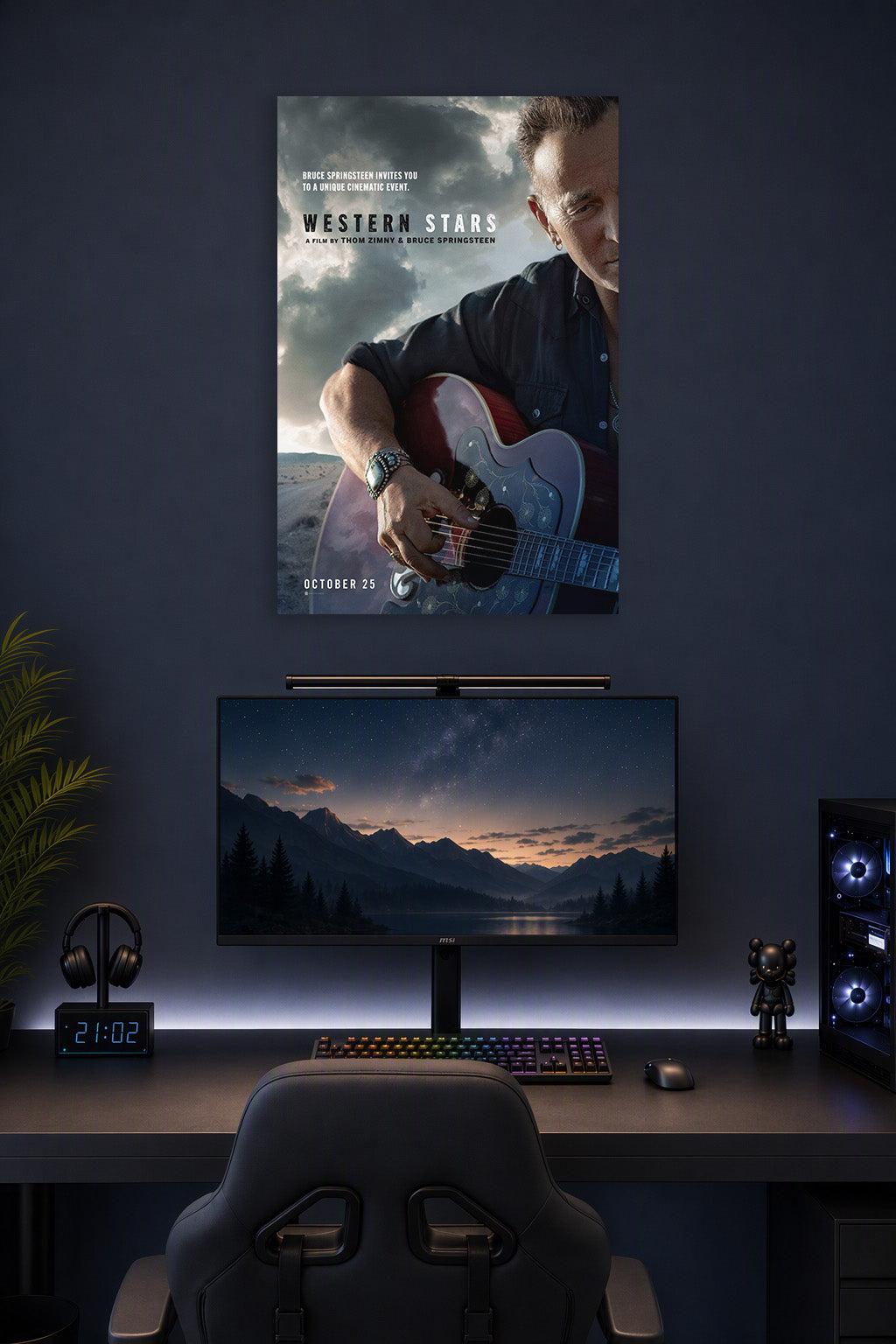 Bruce Springsteen in a gaming desk setup above a monitor.