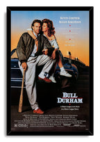 Bull Durham framed wall art print portrays Kevin Costner and Susan Sarandon on a car, with a baseball bat and black frame.