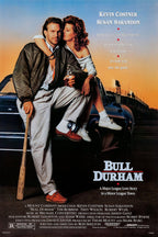 Bull Durham movie poster features Kevin Costner seated with Susan Sarandon on a car, holding a bat at sunset.