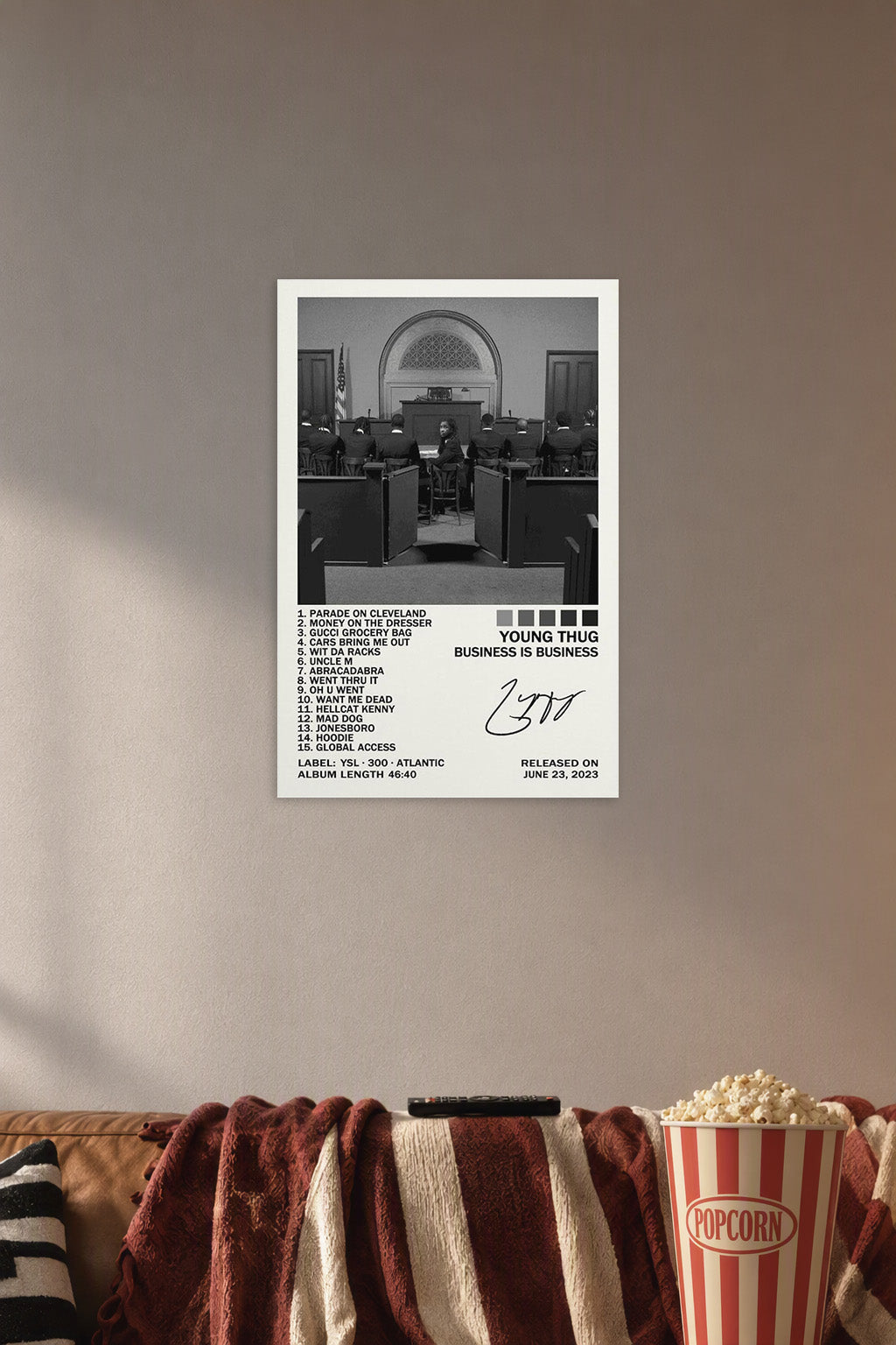 Business Is Business Poster in a cozy movie room above a brown sofa with popcorn.