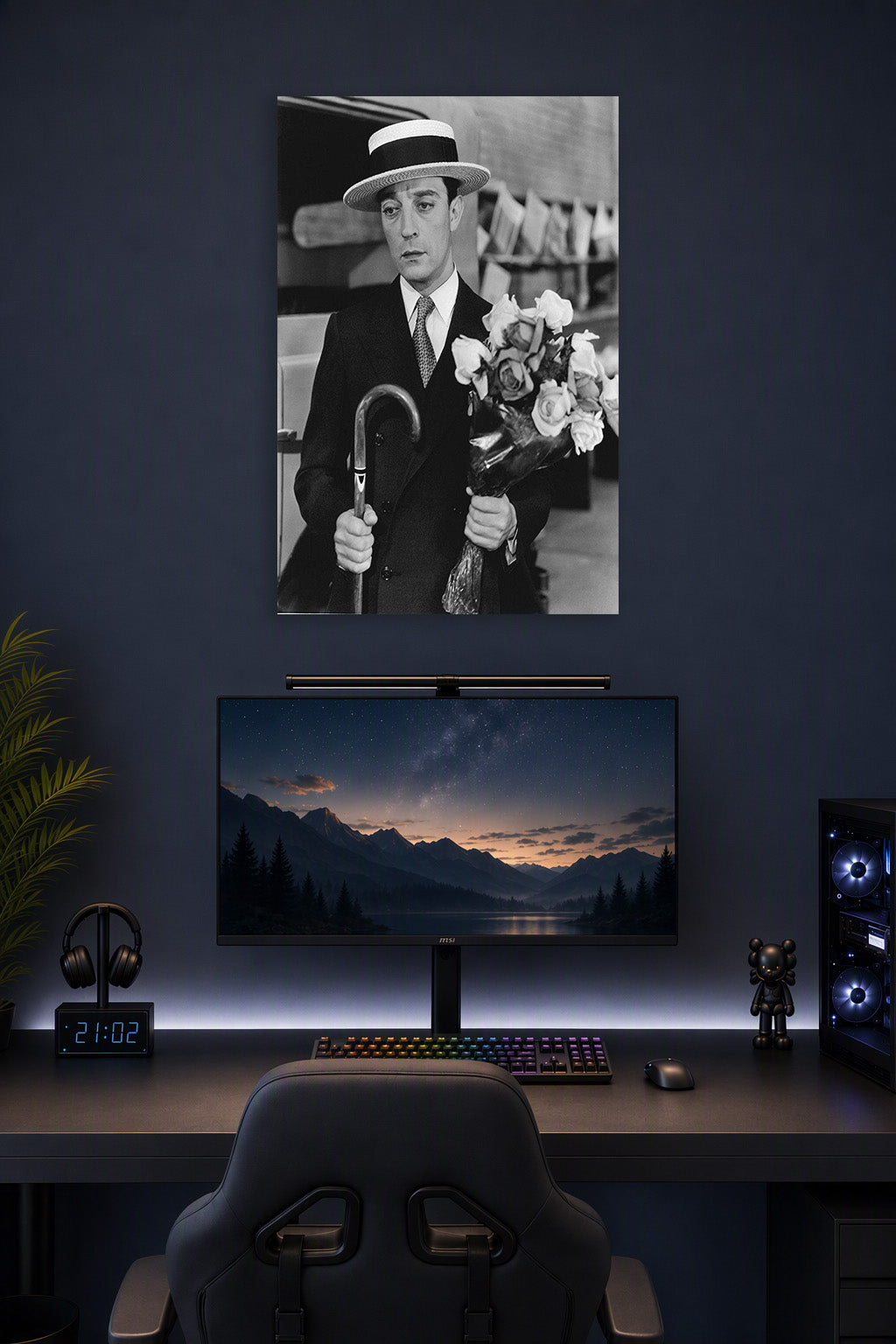 Buster Keaton in a gaming desk setup above a monitor.