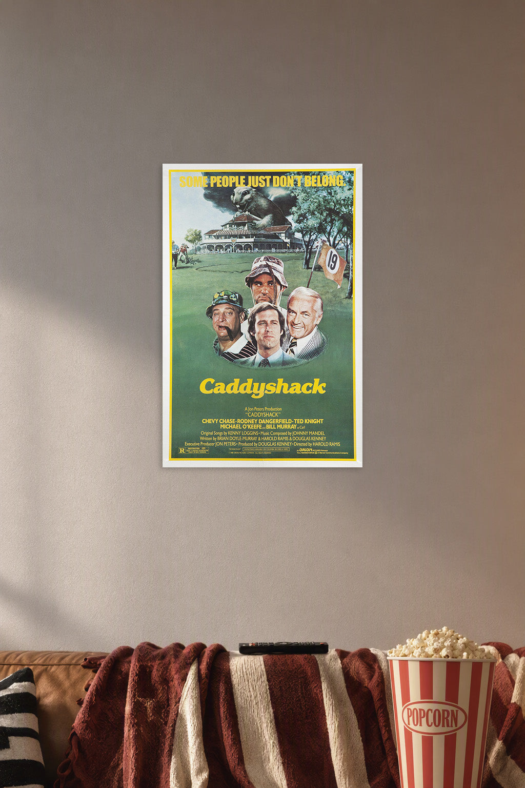 Caddyshack Movie Poster in a cozy movie room above a brown sofa with popcorn.
