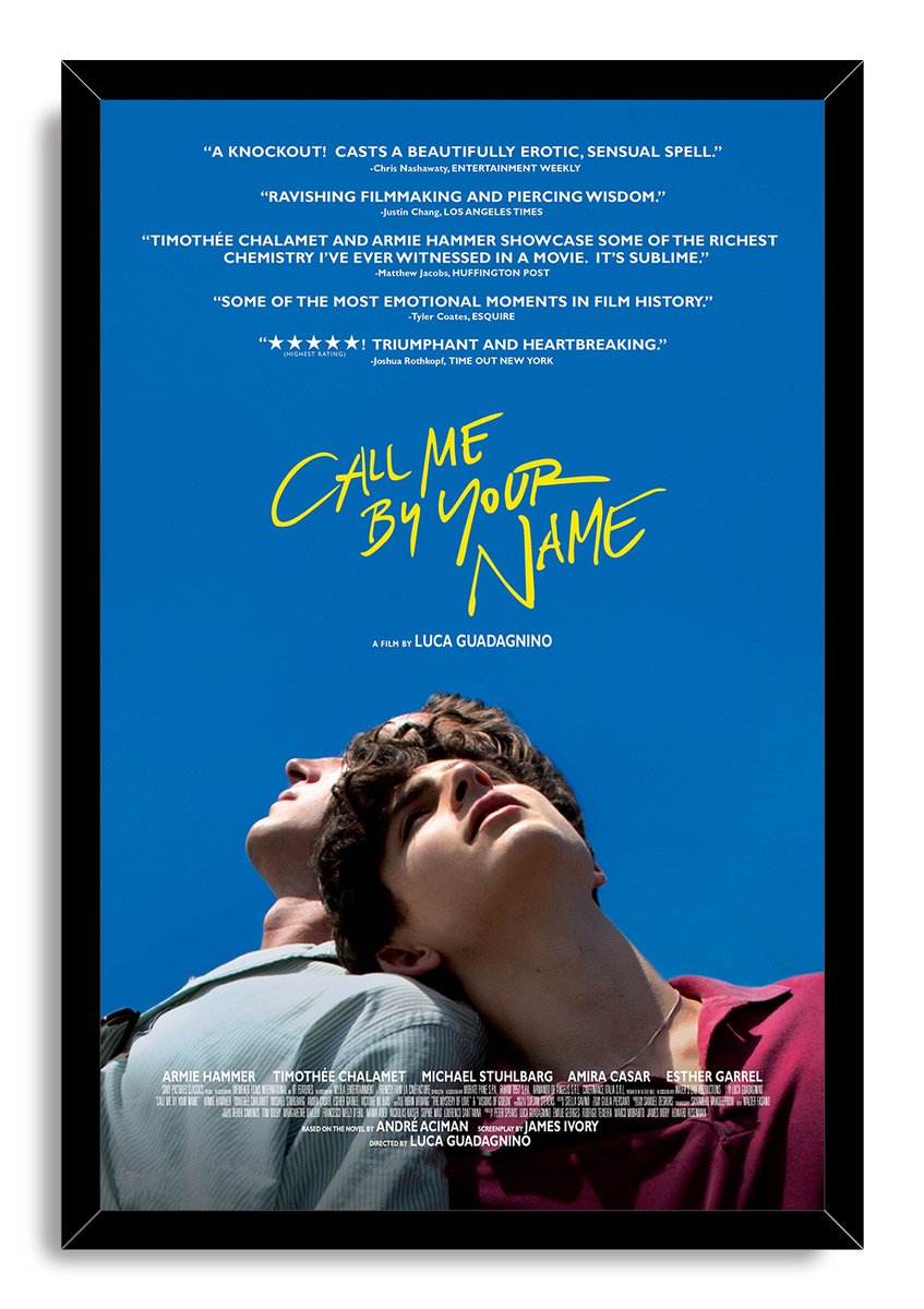 Call Me By Your Name framed wall art print with black border, yellow title text, review quotes, and two men looking upward.