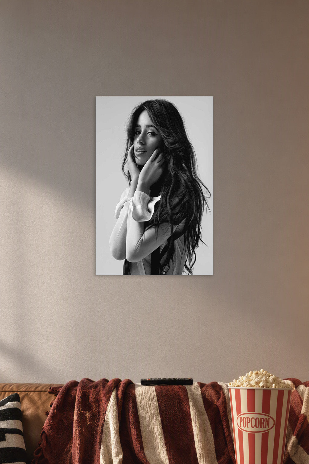 Camila Cabello in a cozy movie room above a brown sofa with popcorn.