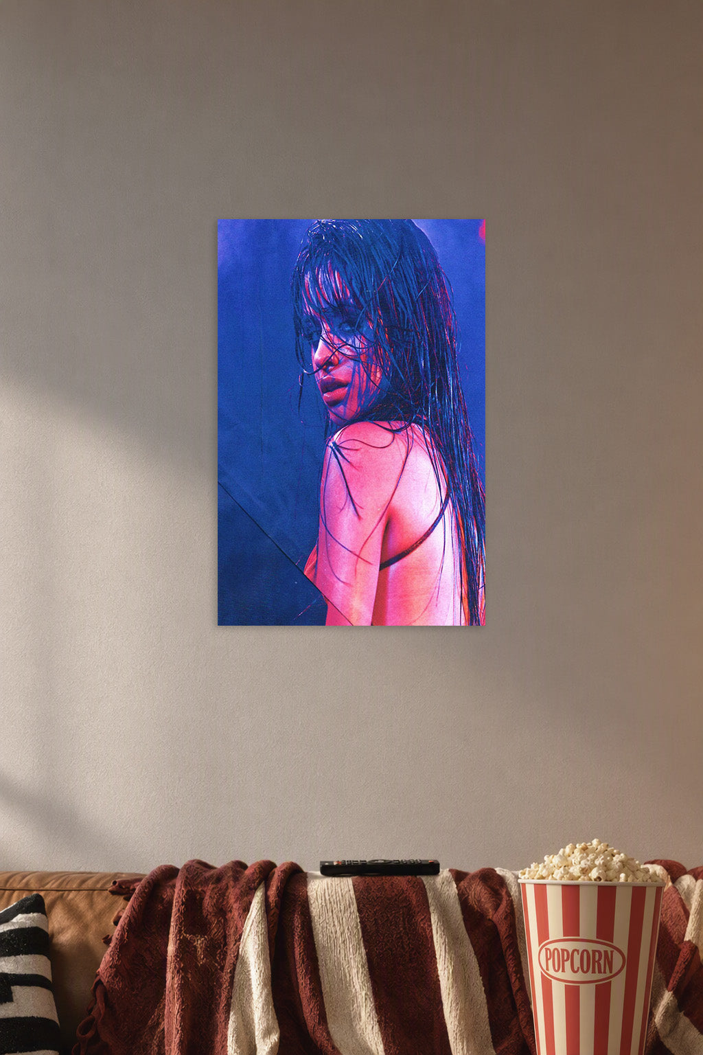 Camila Cabello in a cozy movie room above a brown sofa with popcorn.