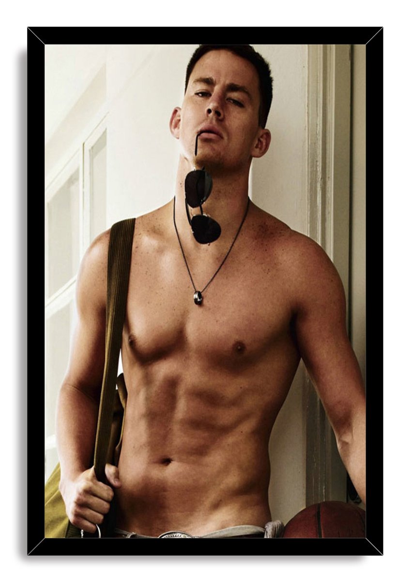 Channing Tatum framed wall art print presents a shirtless man holding sunglasses, set in a black frame against a white background.