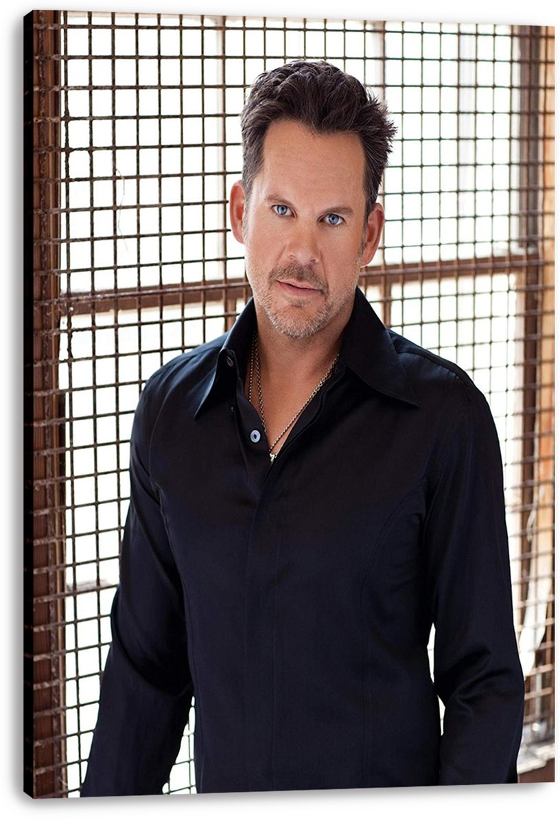 Male celebrity canvas wall art print featuring a blue-eyed man in a dark shirt against a bright gridded window.