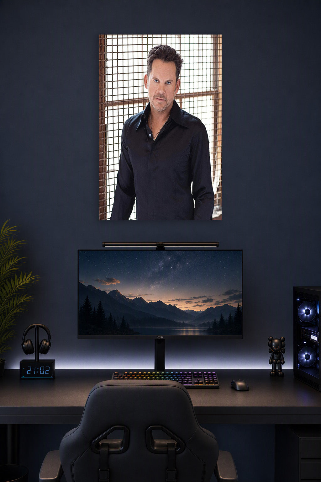 Charismatic Male Celebrity in a gaming desk setup above a monitor.
