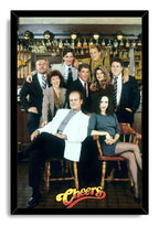 Cheers framed wall art print featuring the ensemble in a classic bar interior, set in a slim black frame with the logo below.