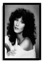 Cher framed wall art print displays a black-and-white portrait of the singer in a white off-shoulder wrap within a black frame.