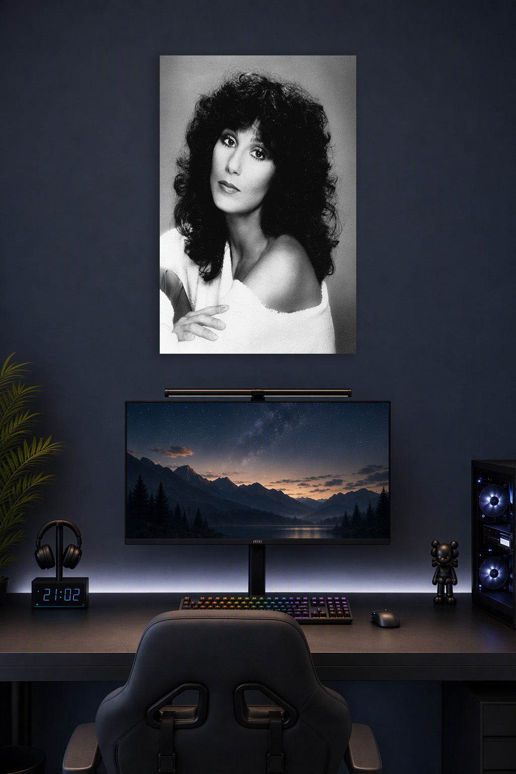 Cher in a gaming desk setup above a monitor.