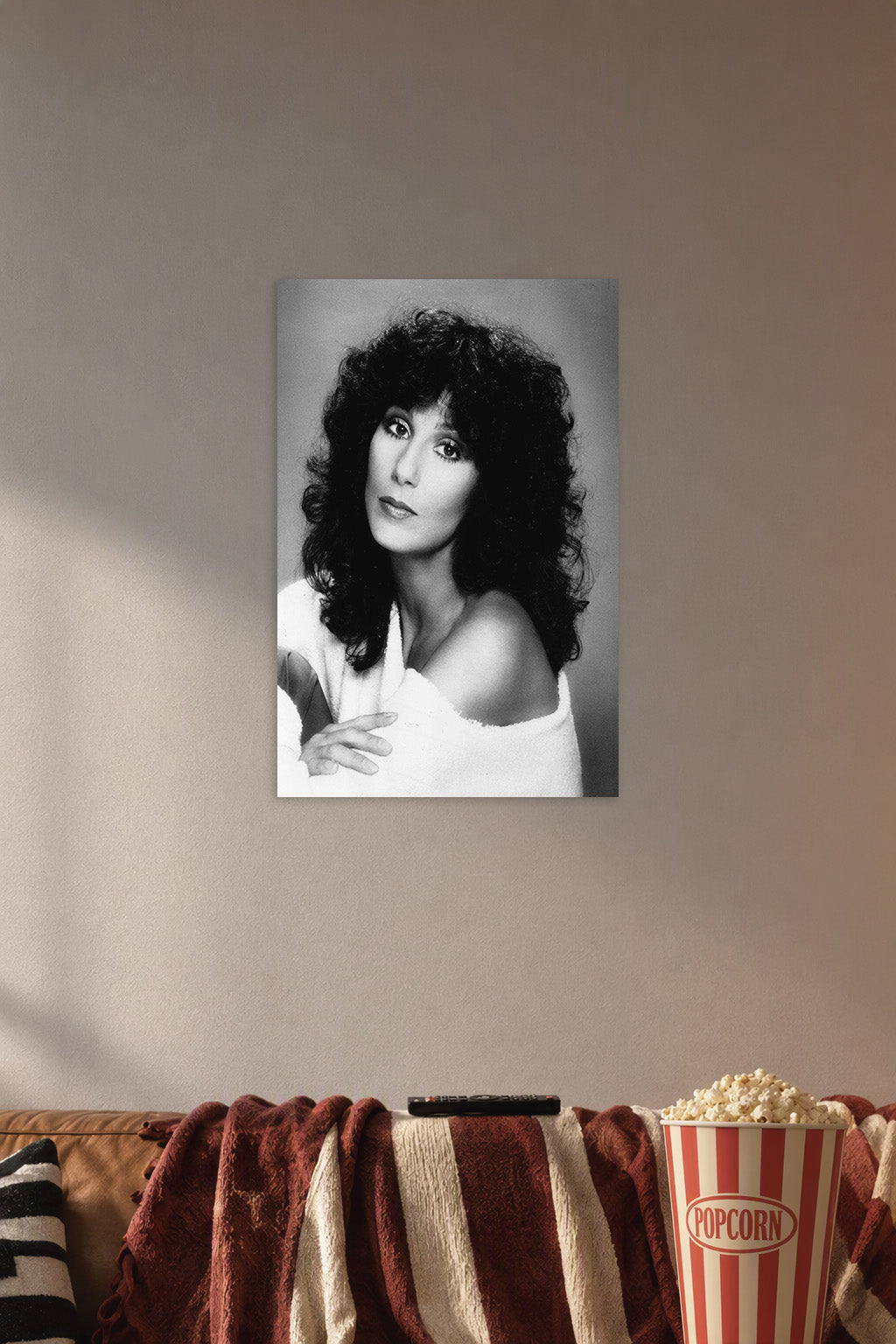 Cher in a cozy movie room above a brown sofa with popcorn.