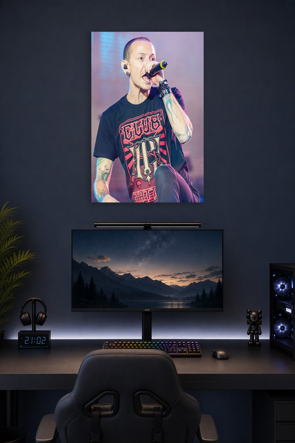Chester Bennington in a gaming desk setup above a monitor.