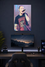 Chester Bennington in a gaming desk setup above a monitor.
