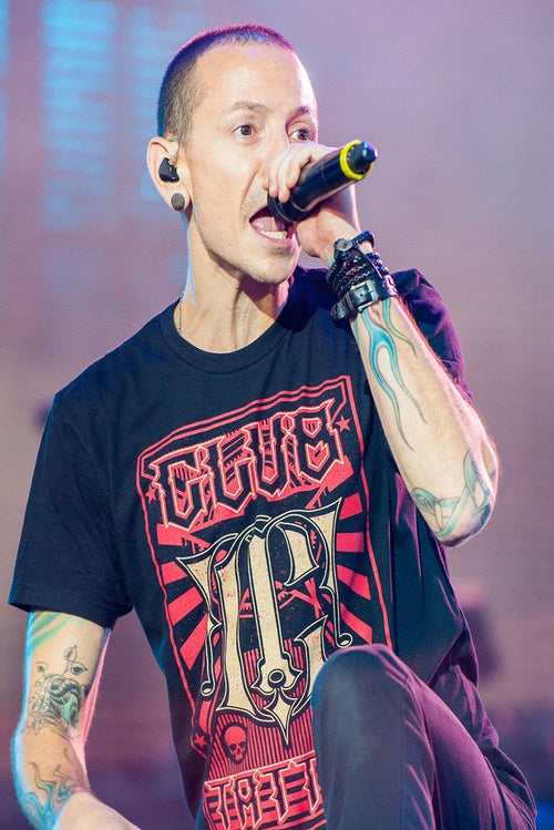 Chester Bennington poster captures the singer performing into a handheld microphone in a black graphic T-shirt under purple stage lights.
