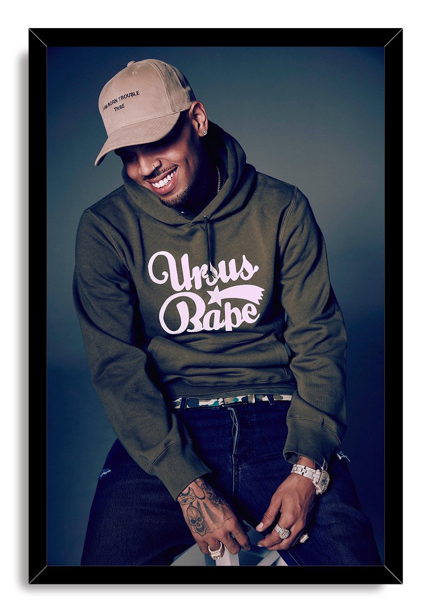 Chris Brown framed wall art print with a black border, portraying the singer in a tan cap and green logo hoodie.
