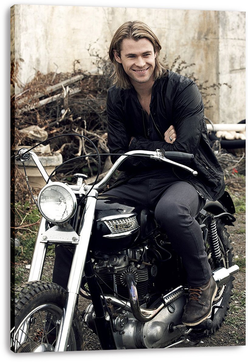 Chris Hemsworth canvas wall art print displays the smiling actor on a black motorcycle, with wrapped edges visible against white.