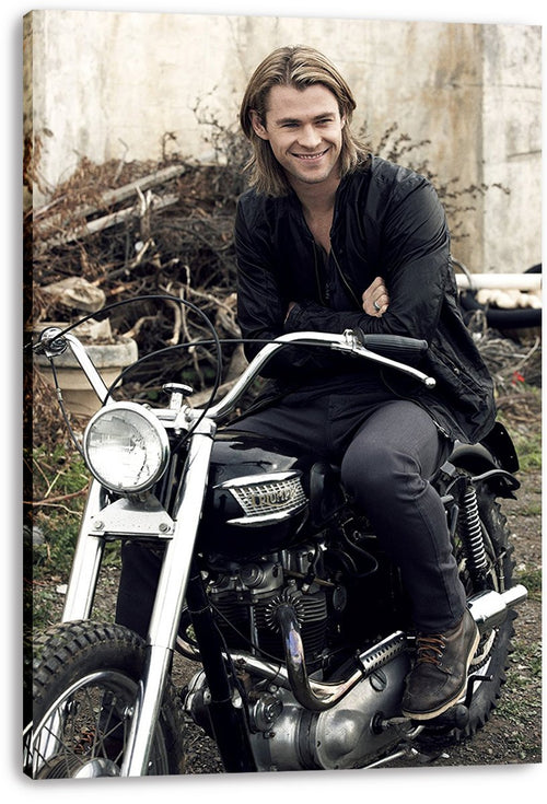 Chris Hemsworth canvas wall art print displays the smiling actor on a black motorcycle, with wrapped edges visible against white.