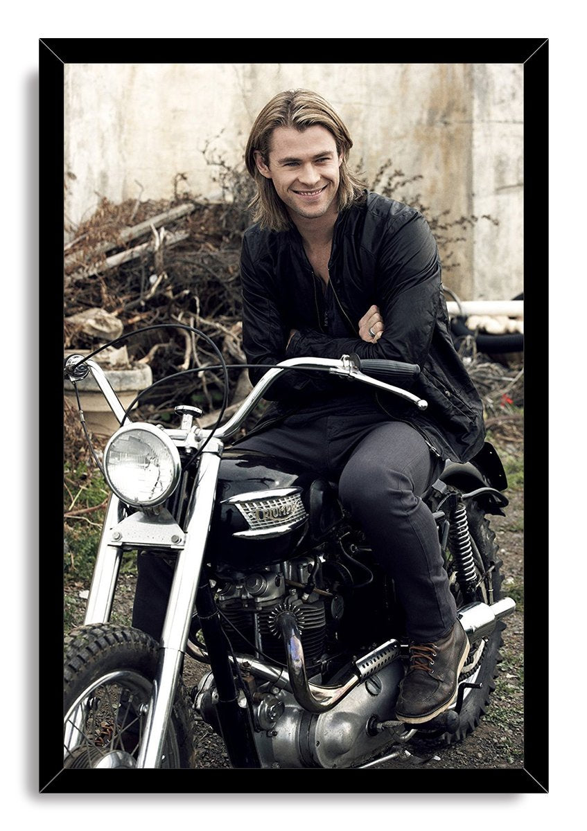 Chris Hemsworth framed wall art print features the actor smiling on a black motorcycle, presented in a sleek black frame.