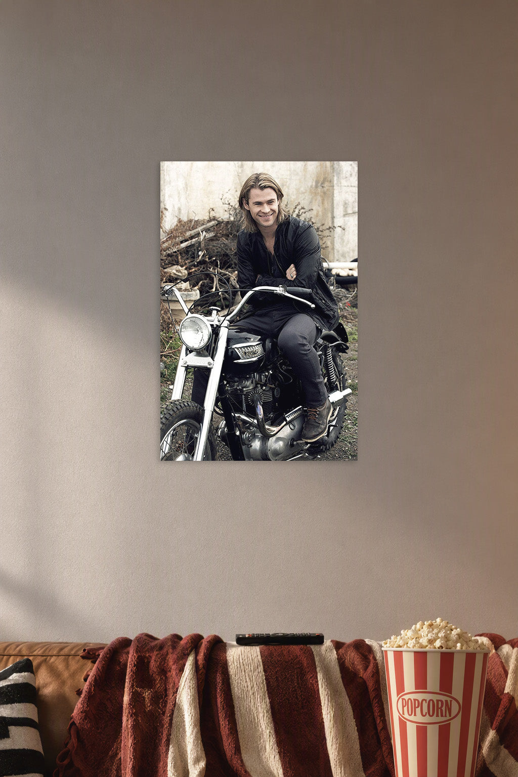 Chris Hemsworth in a cozy movie room above a brown sofa with popcorn.