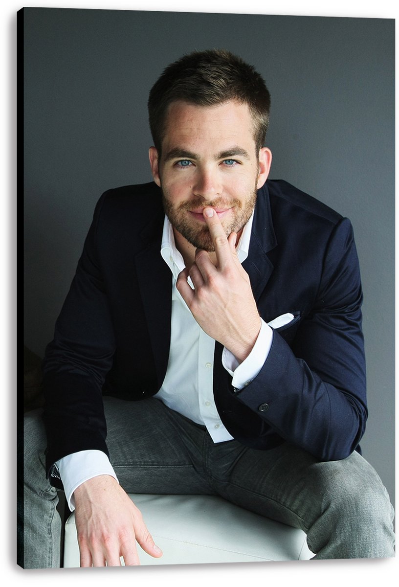 Chris Pine canvas wall art print presents a seated portrait in a navy blazer, white shirt, and gray trousers on a white background.