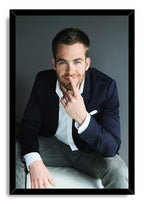 Chris Pine framed wall art print displays a seated portrait with a navy jacket, white shirt, gray trousers, and black border.