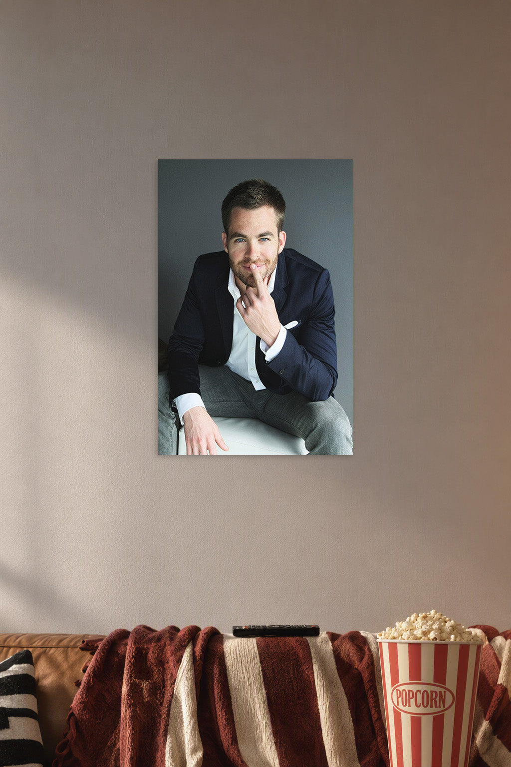 Chris Pine in a cozy movie room above a brown sofa with popcorn.