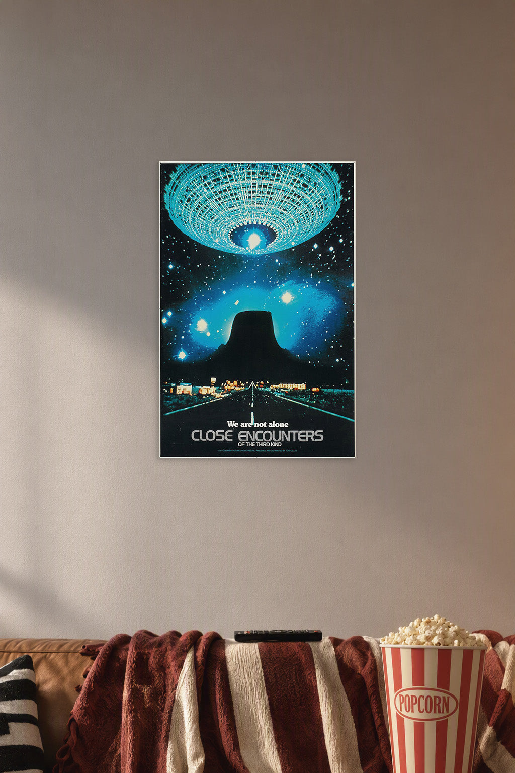 Close Encounters of the Third Kind in a cozy movie room above a brown sofa with popcorn.