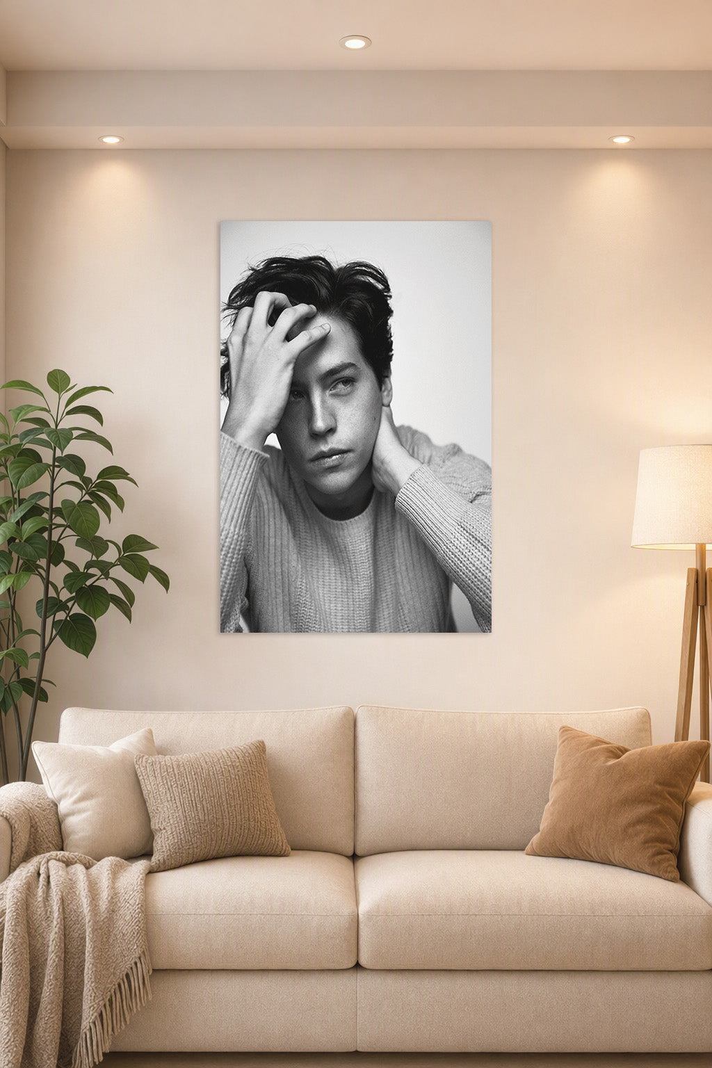 Cole Sprouse in a bright living room above a beige sofa.