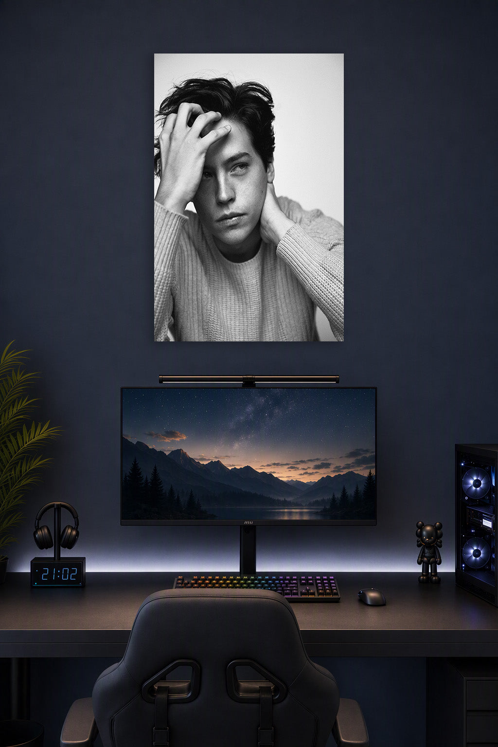 Cole Sprouse in a gaming desk setup above a monitor.