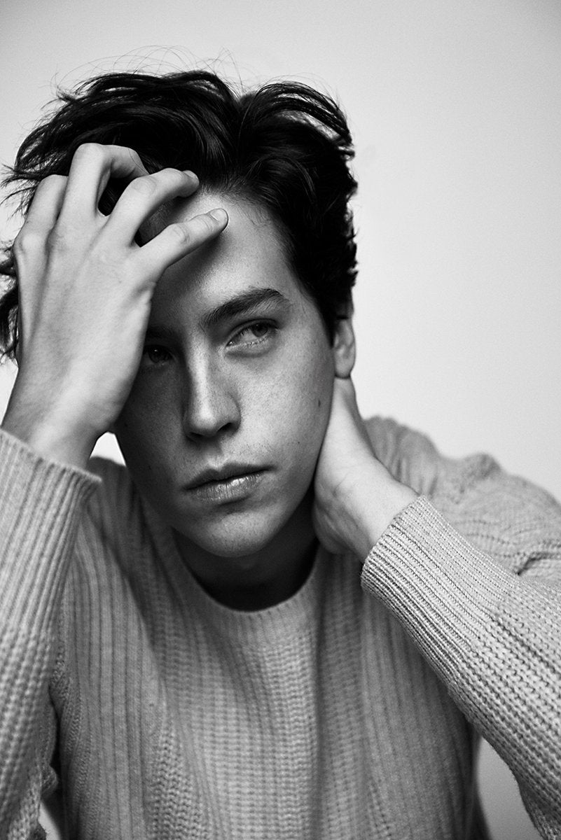 Cole Sprouse poster features a black-and-white close portrait of the actor in a ribbed sweater, hands in his dark hair and at his neck.