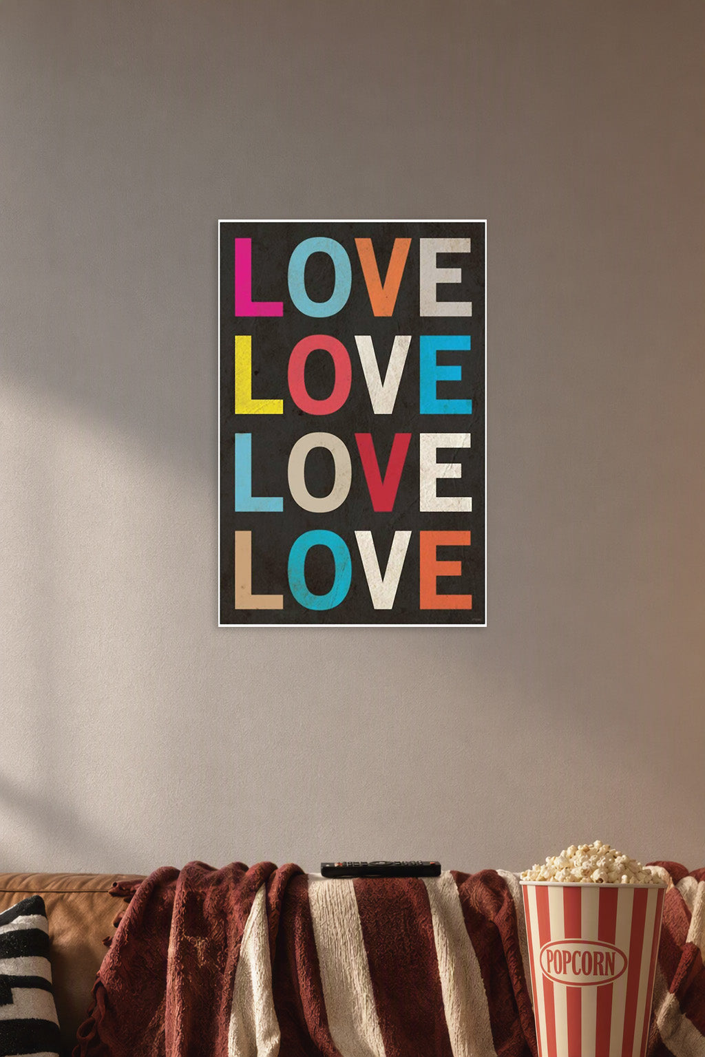 Colorful LOVE Text in a cozy movie room above a brown sofa with popcorn.