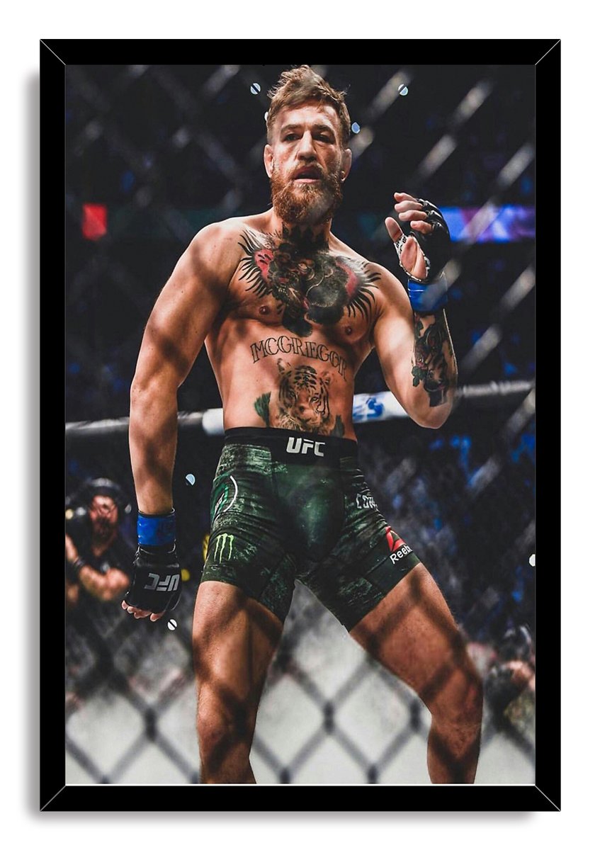 Conor McGregor framed wall art print portrays the tattooed UFC fighter in green shorts behind an octagon fence.