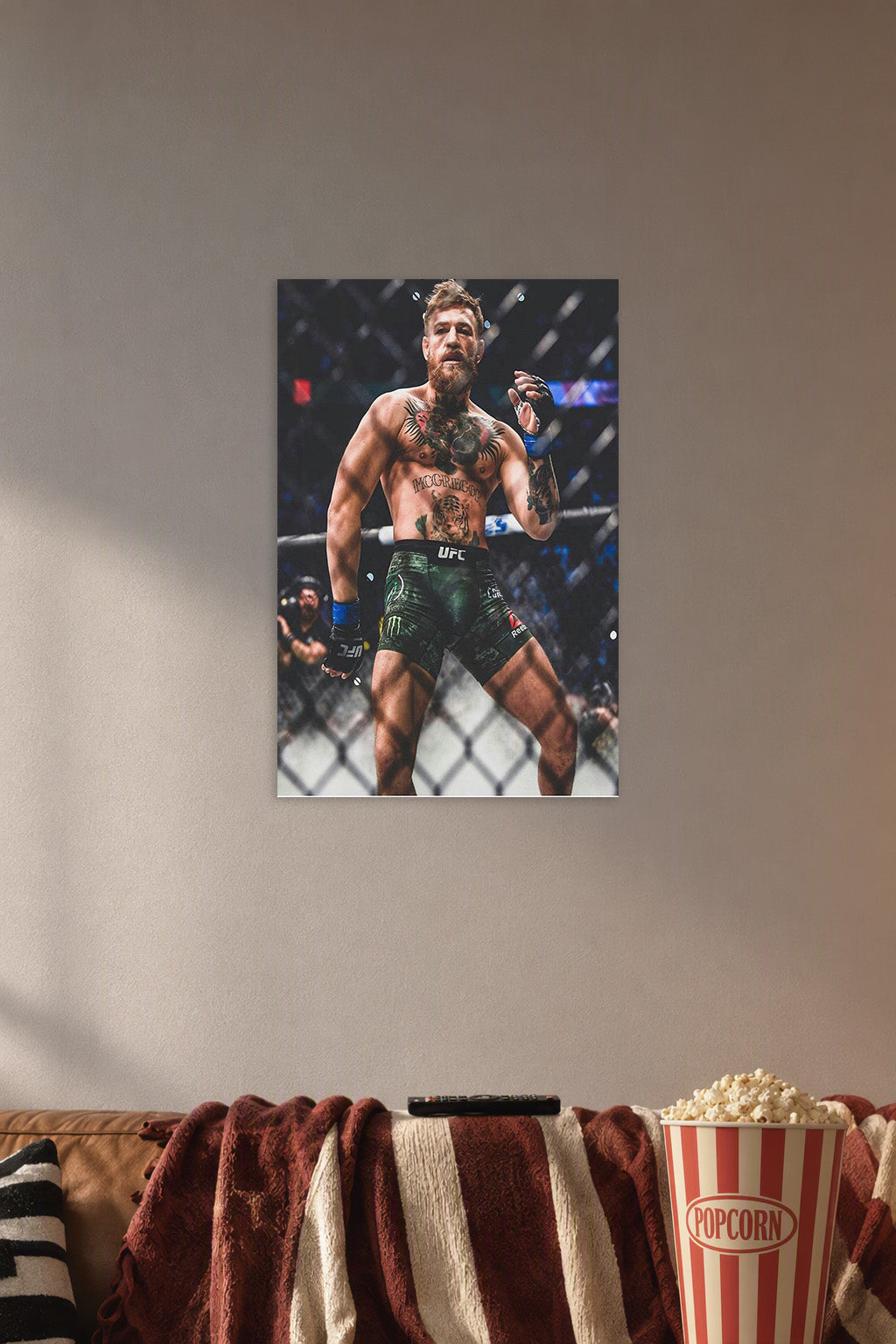 Conor McGregor in a cozy movie room above a brown sofa with popcorn.