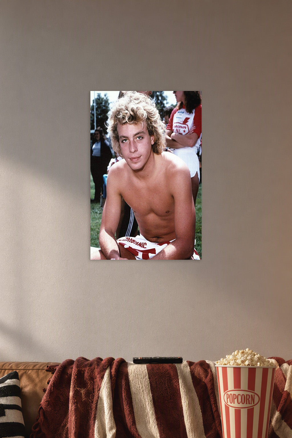 Corey Haim in a cozy movie room above a brown sofa with popcorn.