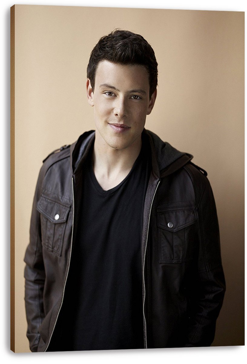 Cory Monteith canvas wall art print featuring a relaxed portrait in a brown jacket and black shirt on a beige backdrop.