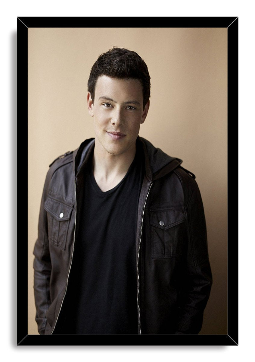 Cory Monteith framed wall art print with a black border, portraying him in a dark jacket against a warm beige background.