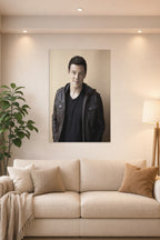 Cory Monteith in a bright living room above a beige sofa.