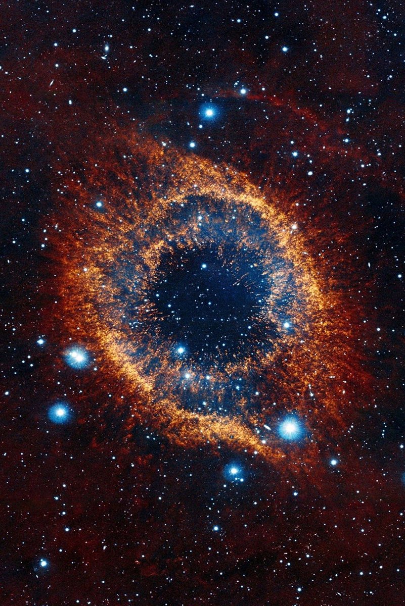 Helix Nebula wall art print depicts a glowing orange gas ring around a deep blue center amid red space and bright stars.
